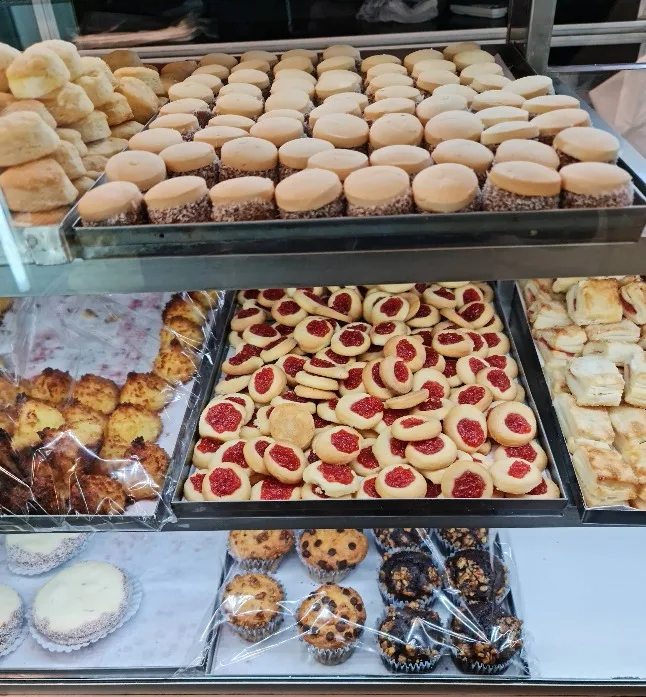 Vitrina con pepas, alfajores de maicena, facturas y muffins recién horneados